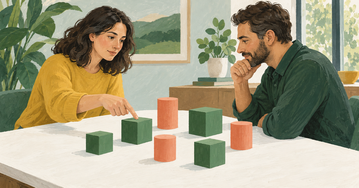 Two people view the same arrangement of green and coral objects from opposite sides of a table.